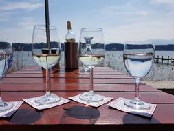 wine glasses on the table by the lake