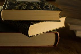 Stack of the colorful literature books, with the yellow pages, in shadow and light