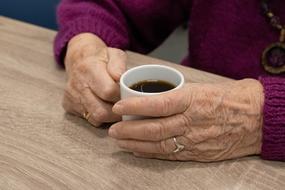 the hands of a man with a coffee mug