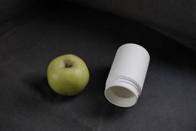 ripe apple and a white jar