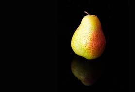 ripe pear on black background