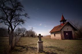 cemetery with a house and trees