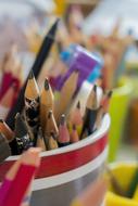 many pencils in a stand in a blurred background
