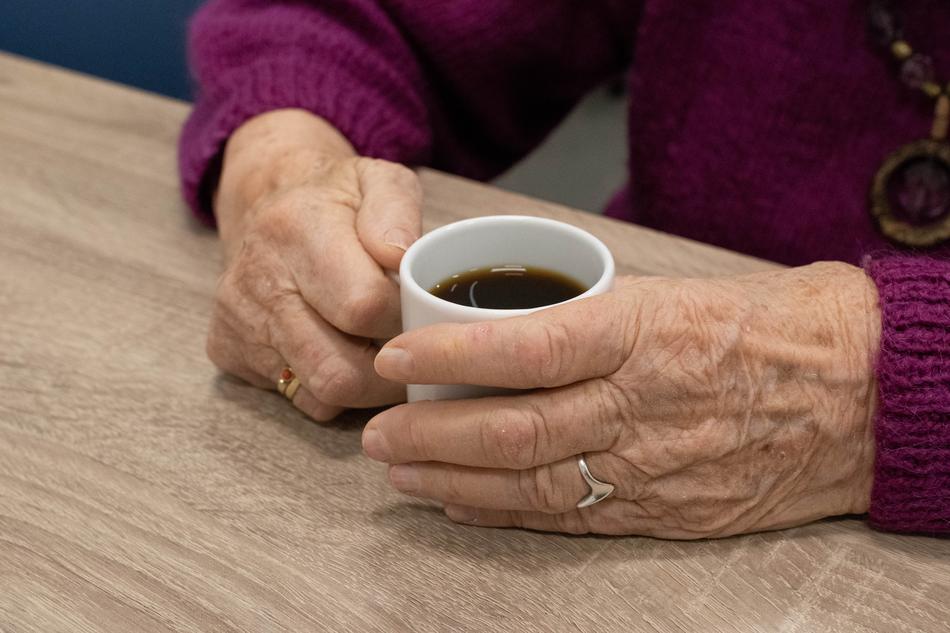 the hands of a man with a coffee mug