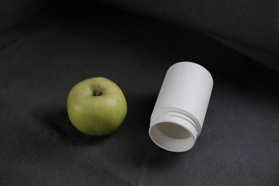 ripe apple and a white jar