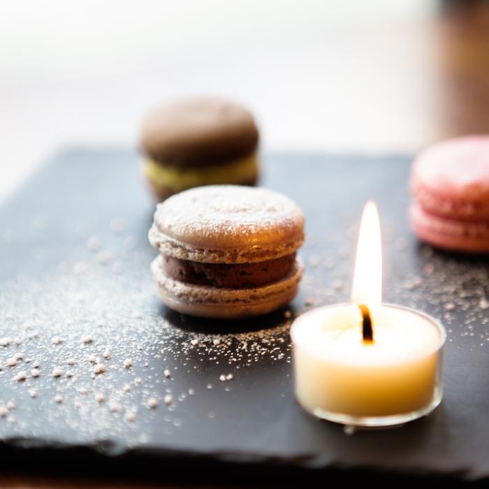 burning candle in the background of desserts