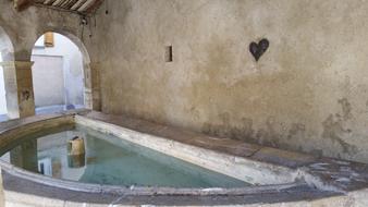 carved heart in the wall by the pool