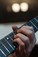 fingers on Guitar strings close up