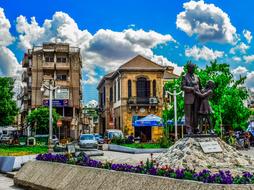 yellow houses with trees and a statue