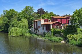 a house in green trees by the river