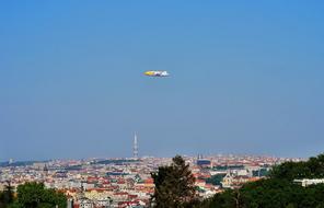 an airplane in the blue sky over the city