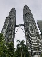 two towers with a bridge against the clouds