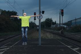 a man in a green T-shirt on the tracks.