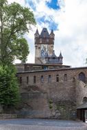 an old castle with trees and clouds