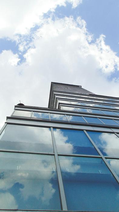 glass building with clouds