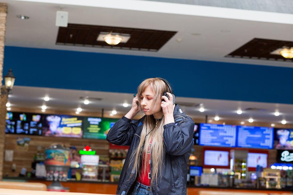 girl with headphones in the lobby of the cinema