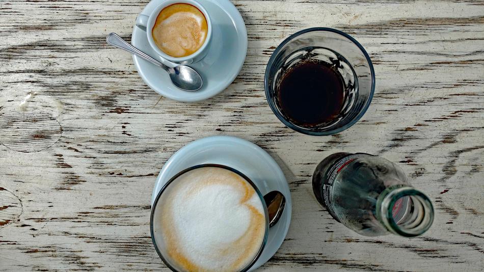 hot coffee with a fizzy drink on the table