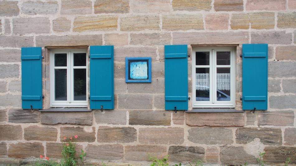 the house with blue shutters on the stone