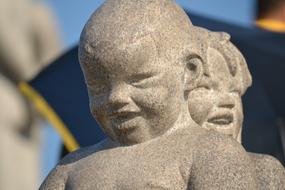 stone sculpture of children on a blue background