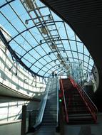 escalator in a shopping center with a glass roof