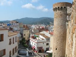 an old tower in a city with hills