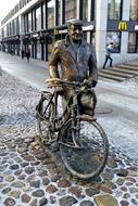 a man with a bicycle is an iron sculpture