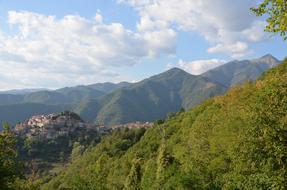 green mountains with grass and clouds