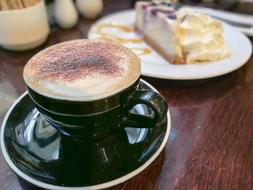Hot coffee with chocolate sprinkles and cream cake