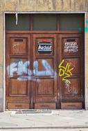 a wooden door with graffiti and paper