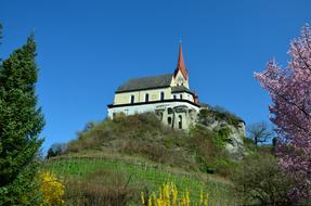 a castle in a green meadow in the mountains.