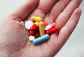 Tablets and colorful capsules on palm, Medicines