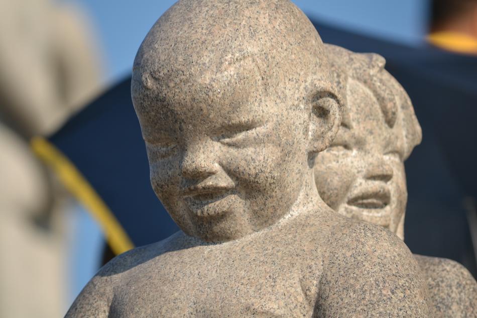 stone sculpture of children on a blue background