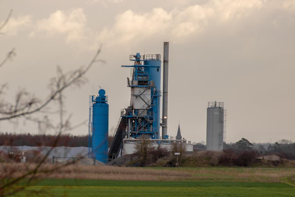 Landscape with the industrial plant among the plants, under the sky with clouds