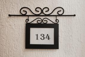 vintage hanging board with 134 number on plastered wall