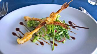 Fried fish on sticks and vegetables