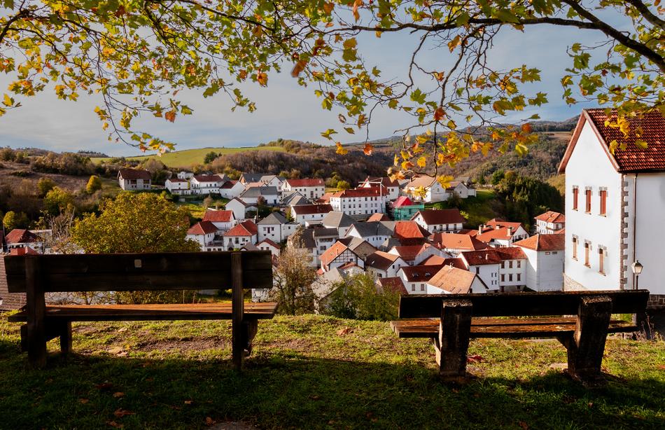 two empty benches in view of picturesque village at autumn, spain, Jaurrieta