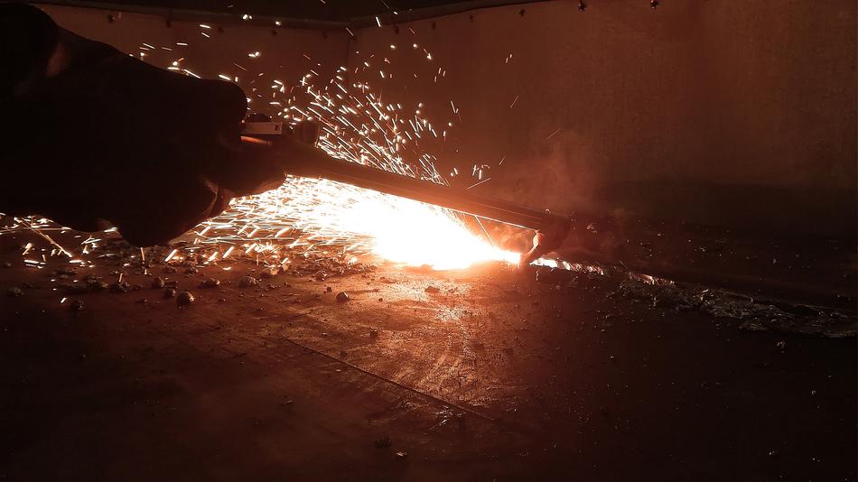Close-up of the metal weld with the tool, among the darkness