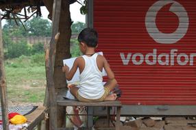 back view of child boy Reading book outdoor
