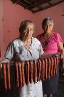 old women with fried sausages