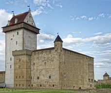 a big castle in the blue sky with clouds.