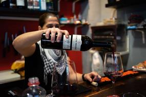 man with a bottle of wine in her hand
