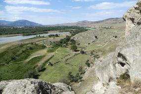 a rocky cliff with a green meadow