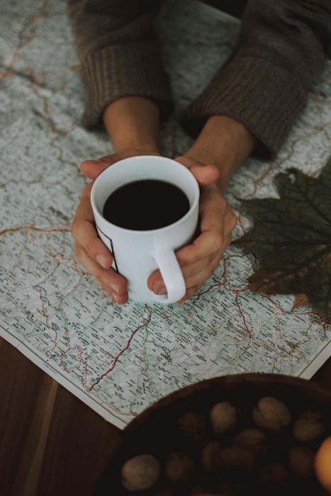 white mug with black coffee in it.