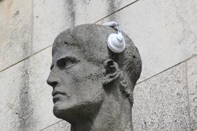 white Headphones on stone male Statue head