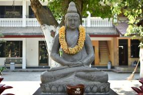 buddha with a wreath around his neck