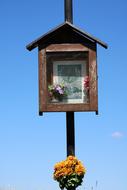 a wooden bird house against the blue sky