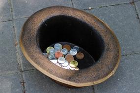 coins in a hat on the street