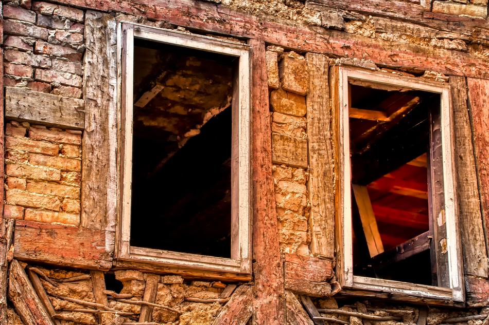 a broken down house with broken windows