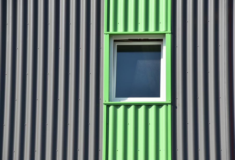 a black house with a green stripe and a window.