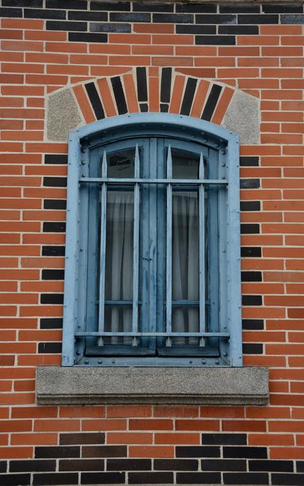 blue window on a brick wall